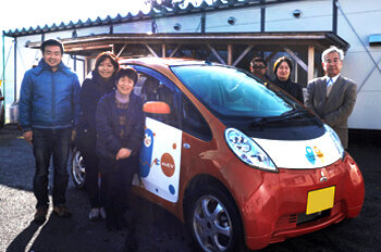 笑顔でシェアカーを囲む人々